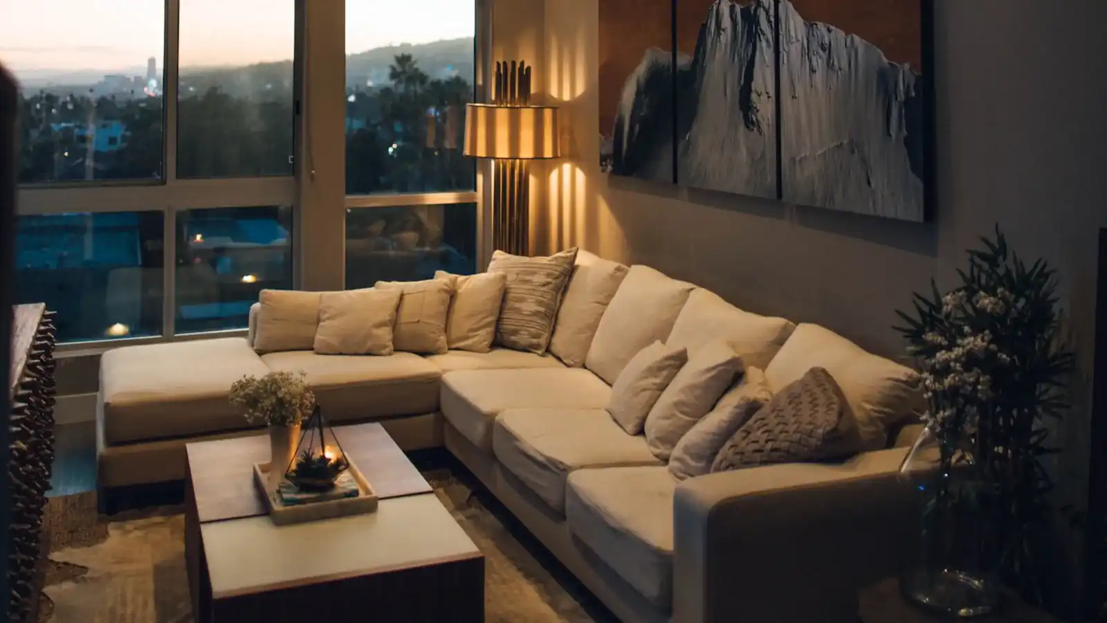 Cozy living room at dusk with warm lighting and a large sofa
